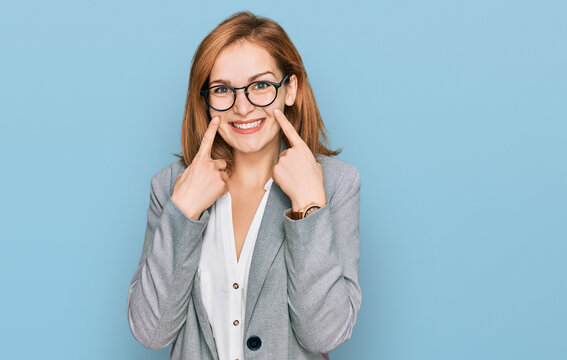 Young caucasian woman wearing business style and glasses smiling with open mouth, fingers pointing and forcing cheerful smile