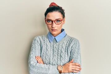 Young caucasian woman wearing casual clothes and glasses skeptic and nervous, disapproving...