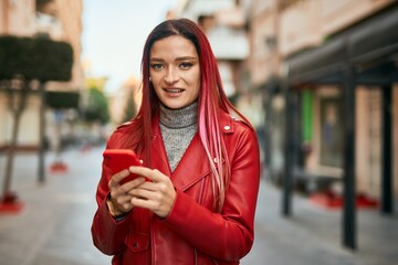 Young caucasian girl smiling happy using smartphone at the city.