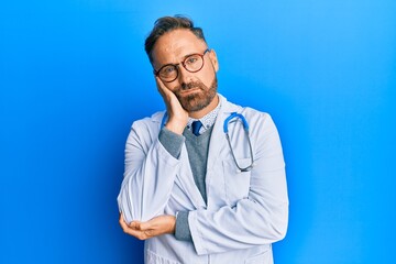 Handsome middle age man wearing doctor uniform and stethoscope thinking looking tired and bored with depression problems with crossed arms.