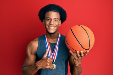 African american man with afro hair wearing winner medals at basketball player smiling happy and...