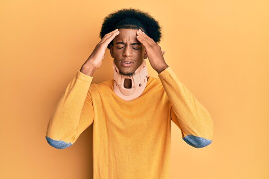 African american man with afro hair wearing cervical neck collar suffering from headache desperate and stressed because pain and migraine. hands on head.