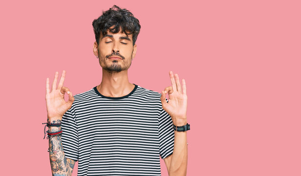 Young hispanic man wearing casual clothes relax and smiling with eyes closed doing meditation gesture with fingers. yoga concept.
