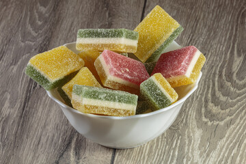 Multi colored layered marmalade in a dish. Closeup of wonderful dessert.