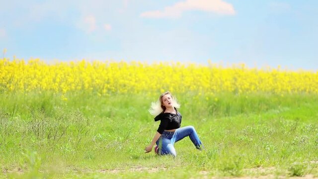 Pretty young woman dance in blooming field