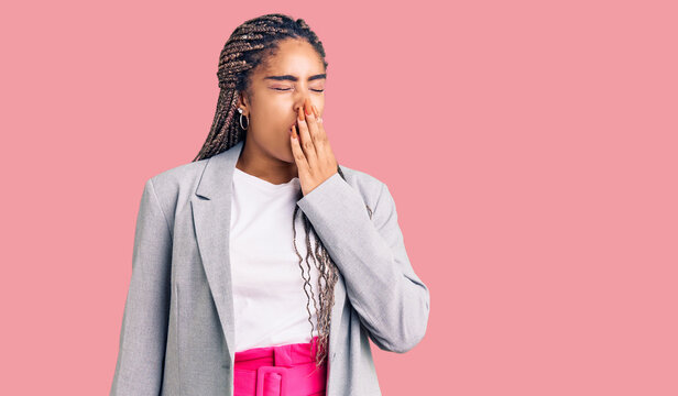 Young african american woman with braids wearing business clothes bored yawning tired covering mouth with hand. restless and sleepiness.