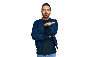 Young hispanic man wearing casual clothes looking at the camera blowing a kiss with hand on air being lovely and sexy. love expression.