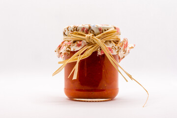 Delicious homemade canned Italian tomato sauce in a glass jar close up isolated on a white background