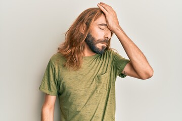 Attractive man with long hair and beard wearing casual clothes surprised with hand on head for mistake, remember error. forgot, bad memory concept.