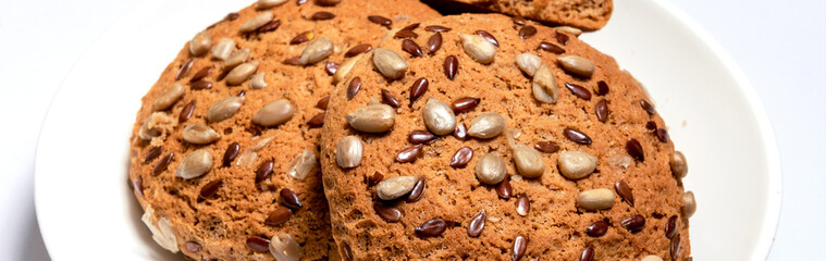Fototapeta na wymiar Banner of fresh oatmeal cookies, gingerbread on a light background. Oatmeal gingerbreads sprinkled with sunflower and flax grains close up