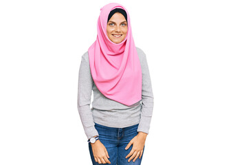 Young caucasian woman wearing traditional islamic hijab scarf looking positive and happy standing and smiling with a confident smile showing teeth