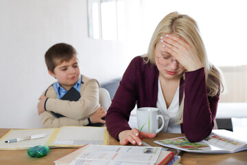 Mother is tired of homeschooling. Boy and woman are arguing at home. Homeoffice with kids