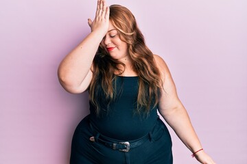 Plus size caucasian young woman wearing casual clothes over pink background surprised with hand on...