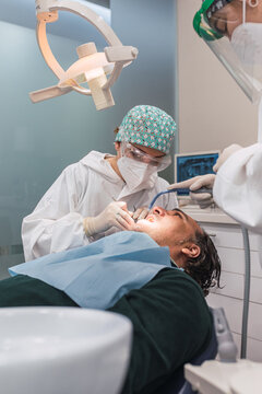 Female dentist with a patient in her office. Patient with open mouth and woman dentist working. dental health concept.