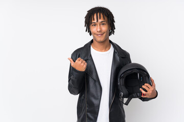 Young african american man holding a motorcycle helmet isolated on white background pointing to the...