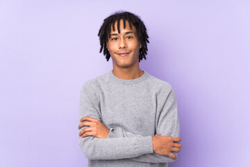 Young african american man isolated on purple background keeping the arms crossed in frontal position