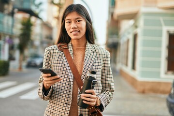 Young asian businesswoman smiling happy using smartphone at the city.