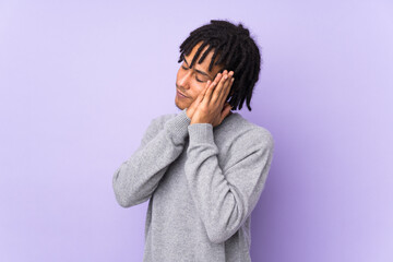 Young african american man isolated on purple background making sleep gesture in dorable expression