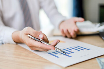 Manager is presenting the company earnings data to the executives, documentation is a bar chart, business administration concept.