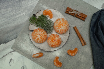 Fototapeta na wymiar Flat lay Christmas composition with fresh tangerines and fir tree branches on grey background. Space for text