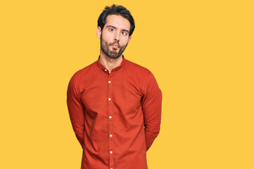 Young hispanic man wearing casual clothes making fish face with lips, crazy and comical gesture. funny expression.