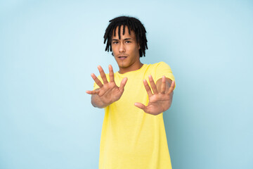 Young african american man isolated on blue background nervous stretching hands to the front