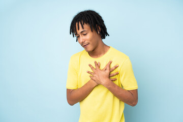 Young african american man isolated on blue background having a pain in the heart