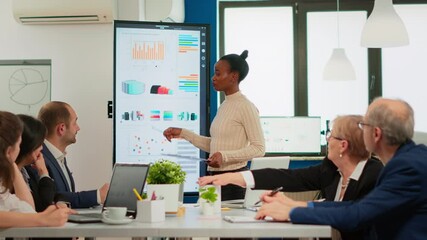 African american coach giving corporate presentation for businesspeople in office, businesswoman explaning business plan on digital board, speaking to clients at meeting working in boardroom. - Powered by Adobe