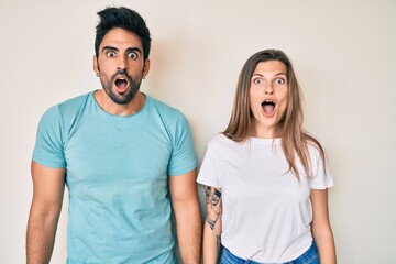 Beautiful young couple of boyfriend and girlfriend together afraid and shocked with surprise and amazed expression, fear and excited face.