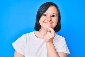 Brunette woman with down syndrome wearing casual clothes smiling looking confident at the camera with crossed arms and hand on chin. thinking positive.