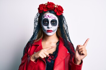 Woman wearing day of the dead costume pointing with fingers to the side skeptic and nervous, frowning upset because of problem. negative person.
