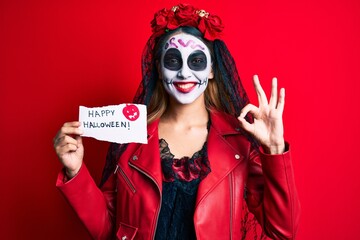 Woman wearing day of the dead costume holding happy halloween paper doing ok sign with fingers, smiling friendly gesturing excellent symbol