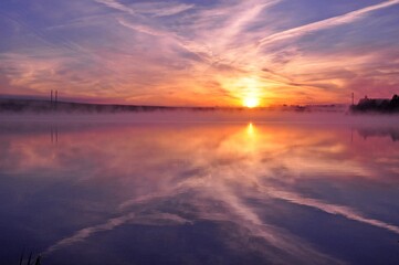 Fototapeta na wymiar Misty beautiful sunrise over water