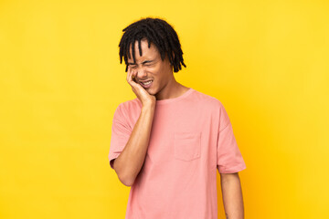 Young african american man isolated on yellow background with toothache