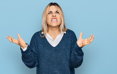 Young caucasian woman wearing casual clothes crazy and mad shouting and yelling with aggressive expression and arms raised. frustration concept.