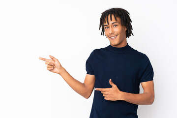 Young african american man isolated on white background surprised and pointing side