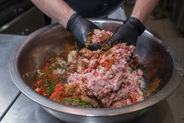 The chef mixes minced pork with different ingredients