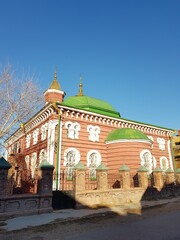 Fototapeta premium Red-brick Muslim mosque with green domes