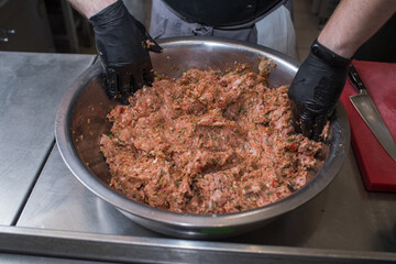 The chef mixes minced pork with different ingredients