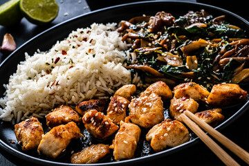 Chicken nuggets with white rice and oyster mushrooms  on wooden table