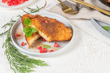 Traditional Christmas Rabanadas with lemon zest, pomegranate, pine nuts and cinnamon. Spanish Torrijas or french toasts close up on the countertop