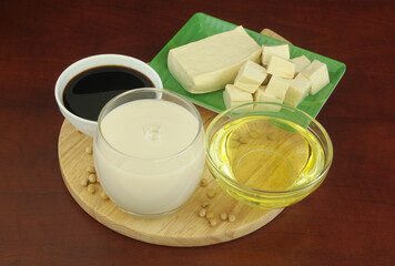 Different soy products - milk, sauce, oil and tofu on cutting board