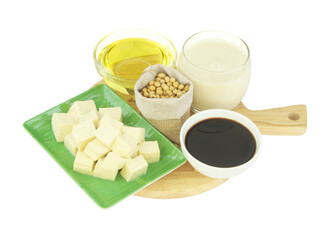 Soybeans in sack and soy products - milk, sauce, oil and tofu on wooden cutting board isolated on white