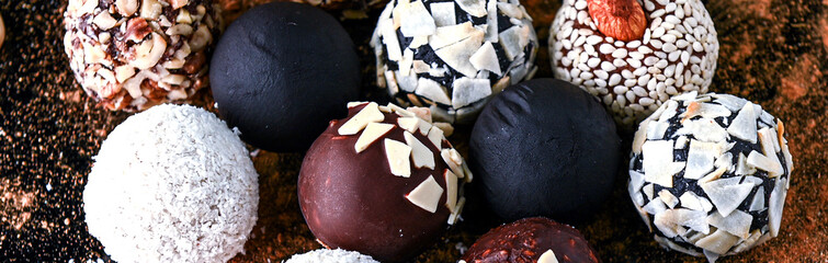 Banner of composition of round homemade candies in dark key. Healthy organic energy balls. Horizontal photo banner for website header design