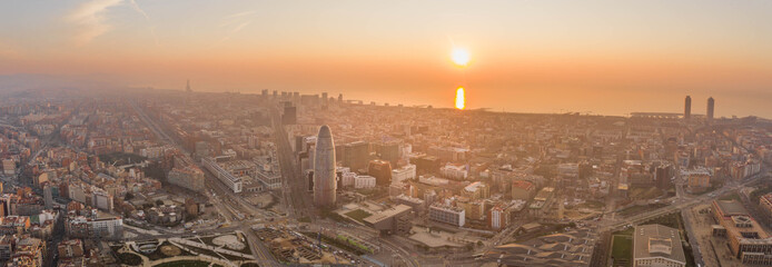 Pano aerial drone shot of Barcelona city with sunrise over horizon