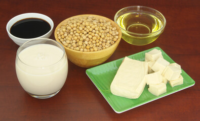 Soy beans and soy products - milk, sauce, oil and tofu on wooden table