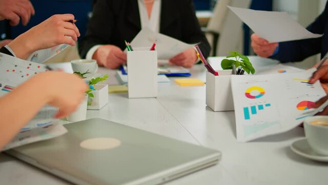 Close up of diverse startup company colleagues meeting in professional workplace, brifing and sharing ideas over financial strategy management. Multiracial business people working together at office.