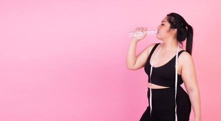Oversize weight loss concept. Chubby overweight fat young woman with measuring tapes drinking fresh...