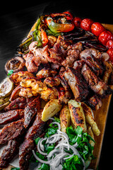 Assorted Mixed different grilled meat with vegetables on table