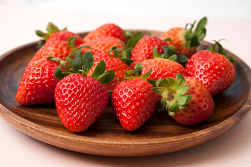 Fresh strawberries in wooden bowl on white background 